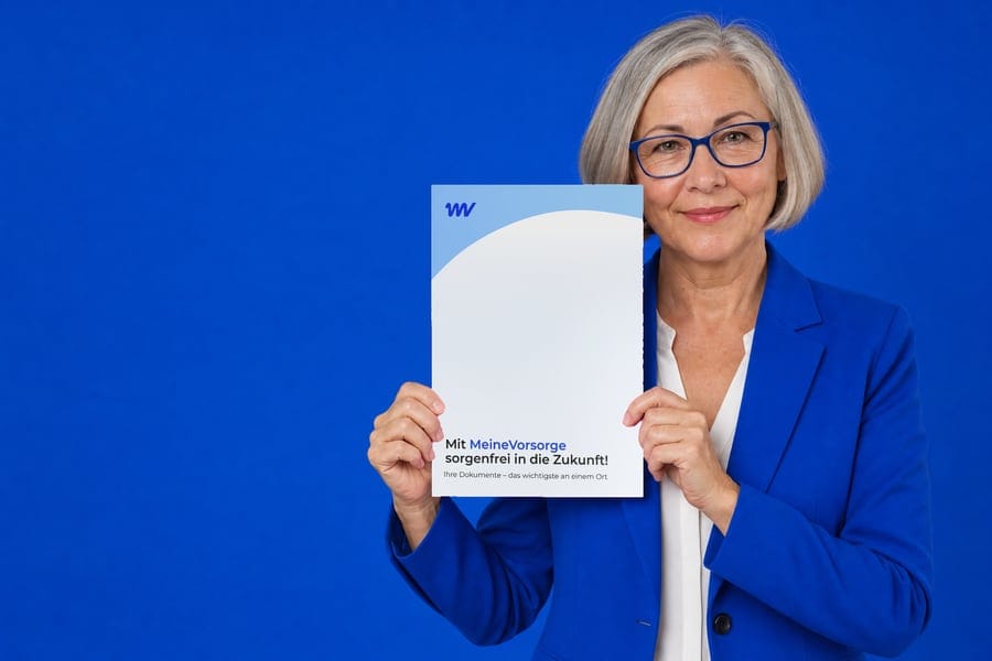 Frau hält die MeineVorsorge Vorsorgemappe vor blauem Hintergrund